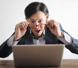 Erfreut ueberraschter Mann vor einem Laptop als Symbolbild fuer das VMware vSphere v9 Training online